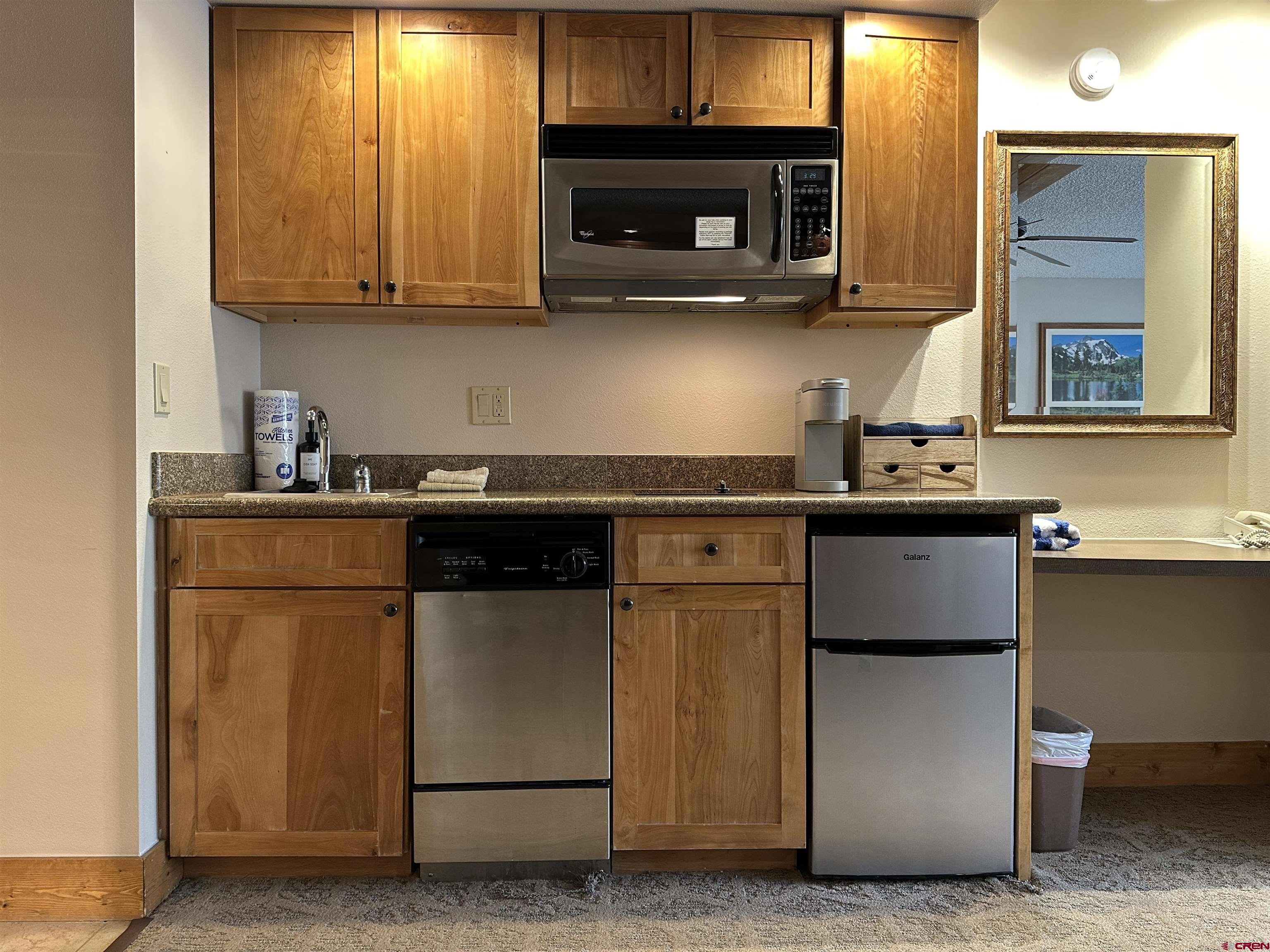 6 Emmons Road, Unit 317 Crested Butte, CO 81225 - Photo 4 of 19 a kitchen with stainless steel appliances granite countertop a sink stove and microwave