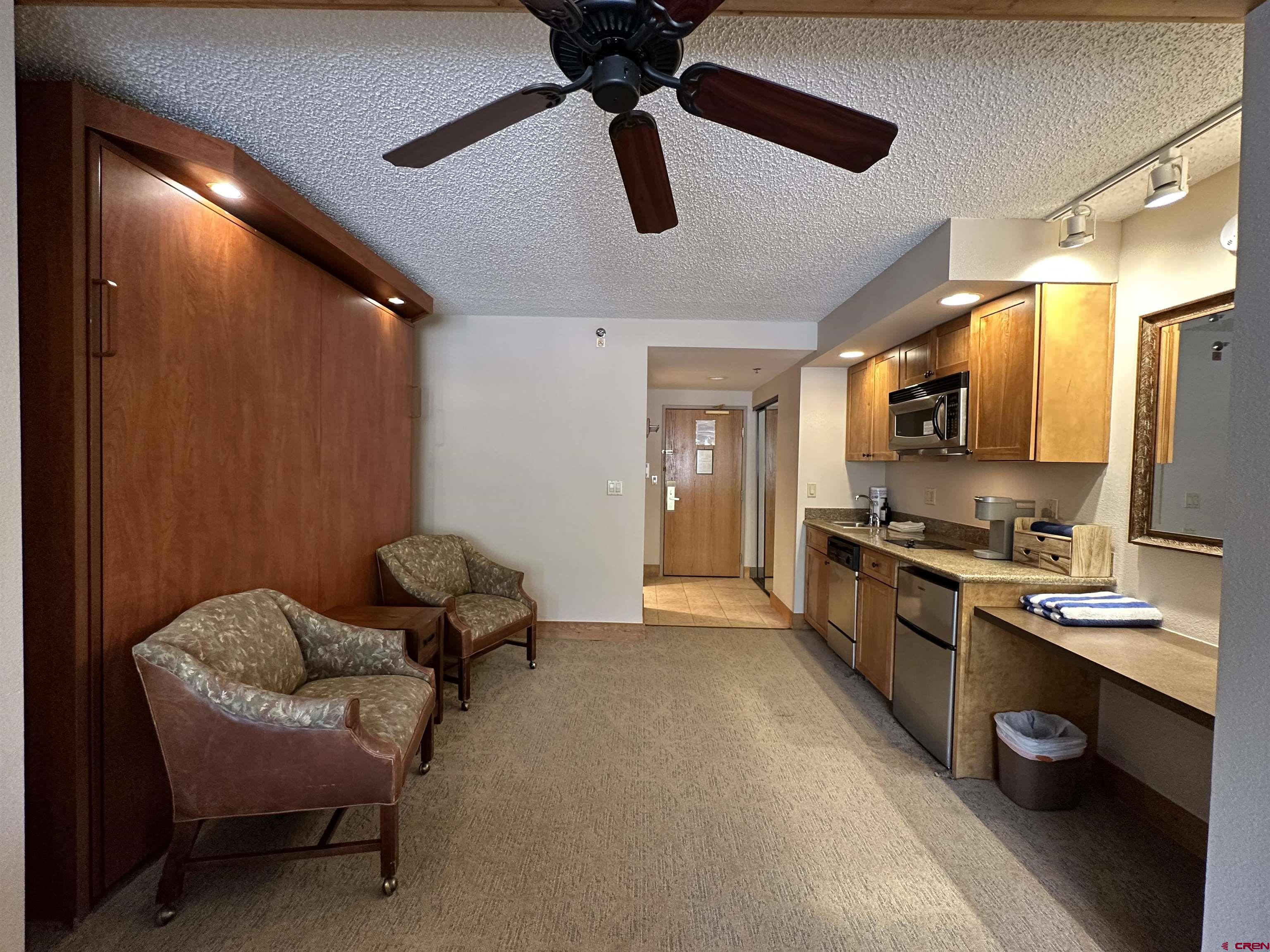 6 Emmons Road, Unit 317 Crested Butte, CO 81225 - Photo 7 of 19 a kitchen with stainless steel appliances kitchen island granite countertop a refrigerator and microwave