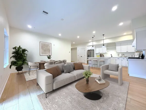 a living room with furniture and a view of kitchen