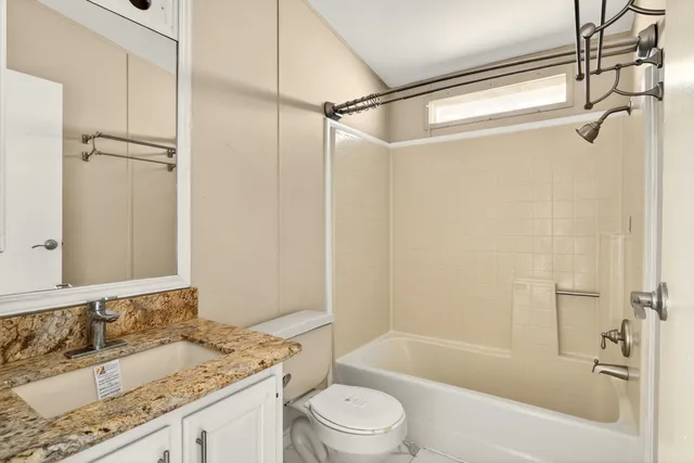 a bathroom with a granite countertop sink toilet and shower