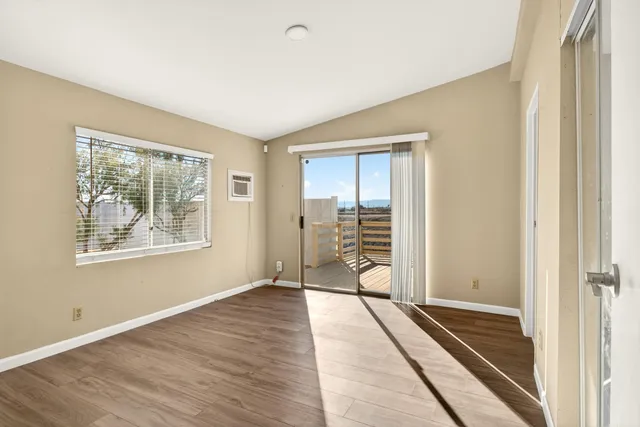 a view of a room with wooden floor and windows