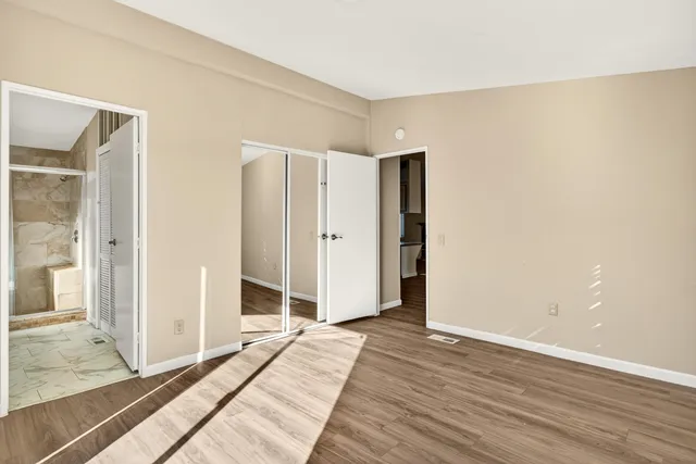 a view of a room with wooden floor and white doors