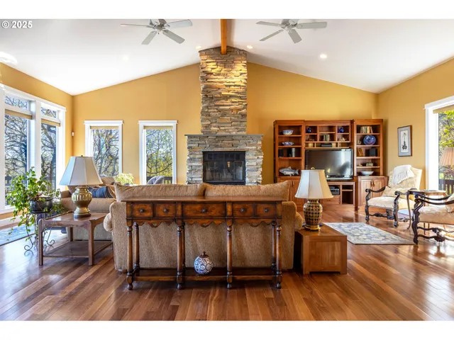 a living room with fireplace furniture and a large window