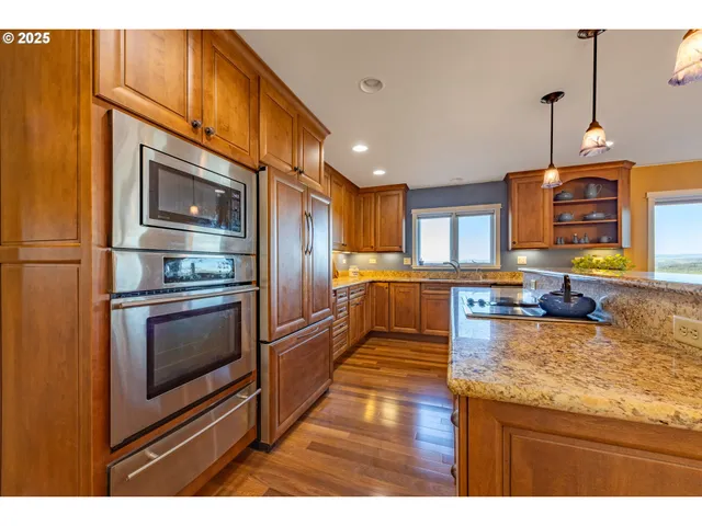 a kitchen with stainless steel appliances granite countertop a stove a sink and a microwave