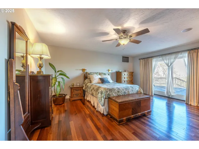 a bedroom with a bed dresser and a large window