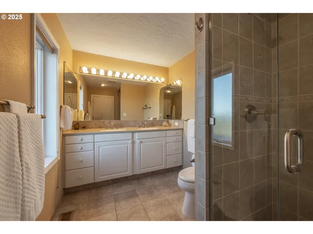 a bathroom with a granite countertop sink mirror and shower