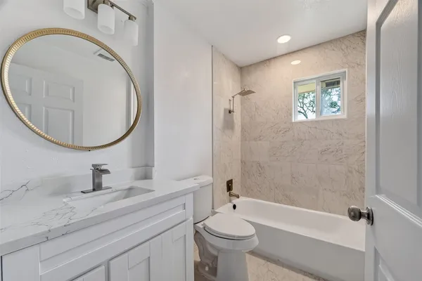 a bathroom with a sink a toilet and a mirror