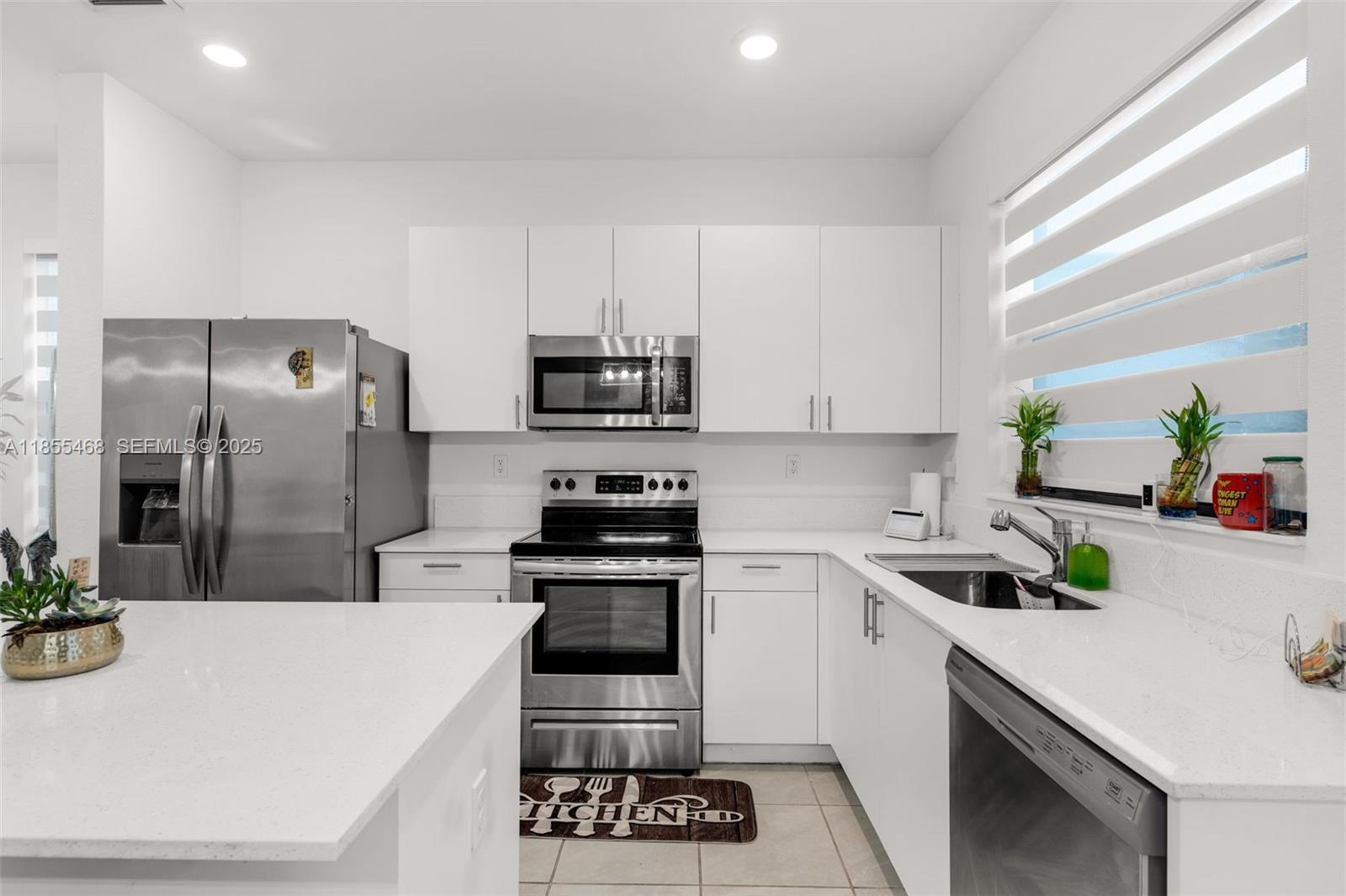 13315 Southwest 285th Street Homestead, FL 33033 - Photo 2 of 31 a kitchen with a sink a stove and refrigerator
