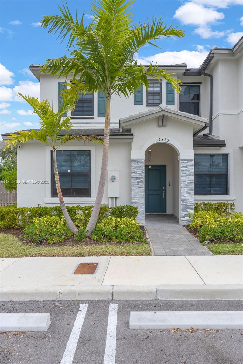 13315 Southwest 285th Street Homestead, FL 33033 - Photo 29 of 31 a front view of a house with a yard and potted plants