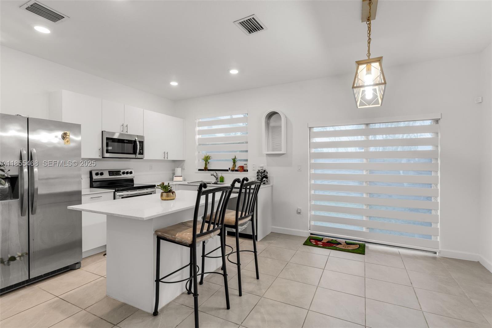 13315 Southwest 285th Street Homestead, FL 33033 - Photo 4 of 31 a kitchen with refrigerator cabinets and window