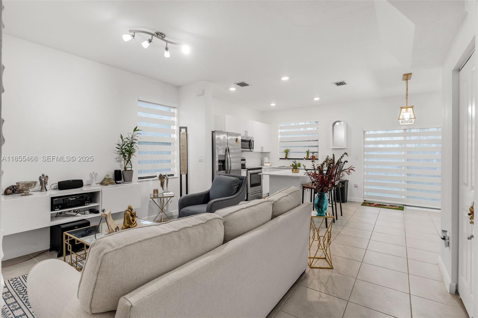 13315 Southwest 285th Street Homestead, FL 33033 - Photo 5 of 31 a living room with furniture and a view of kitchen appliances