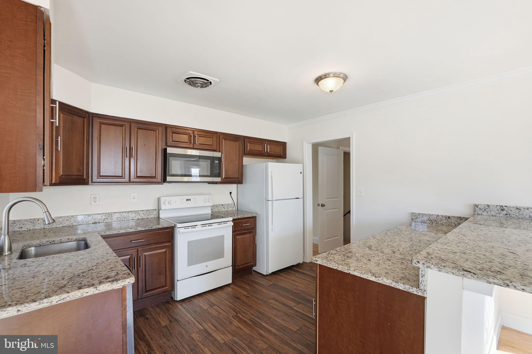 9708 Dameron Drive Silver Spring, MD 20910 - Photo 10 of 38 a kitchen with stainless steel appliances granite countertop a sink stove and refrigerator