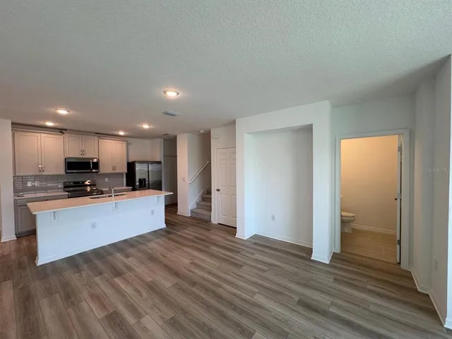 a kitchen with stainless steel appliances kitchen island granite countertop a stove a sink and a refrigerator