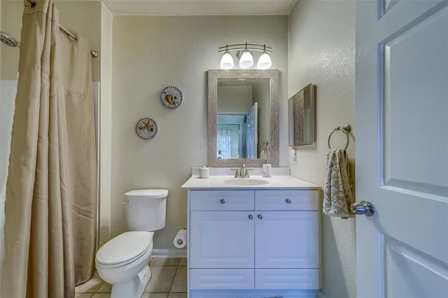 a bathroom with a granite countertop toilet a sink and mirror