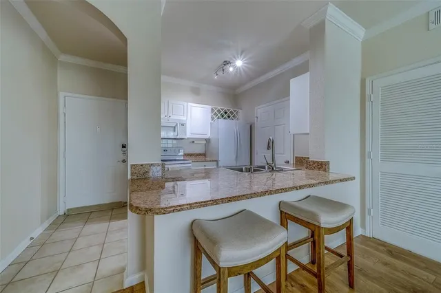 a kitchen with stainless steel appliances granite countertop a sink and a refrigerator
