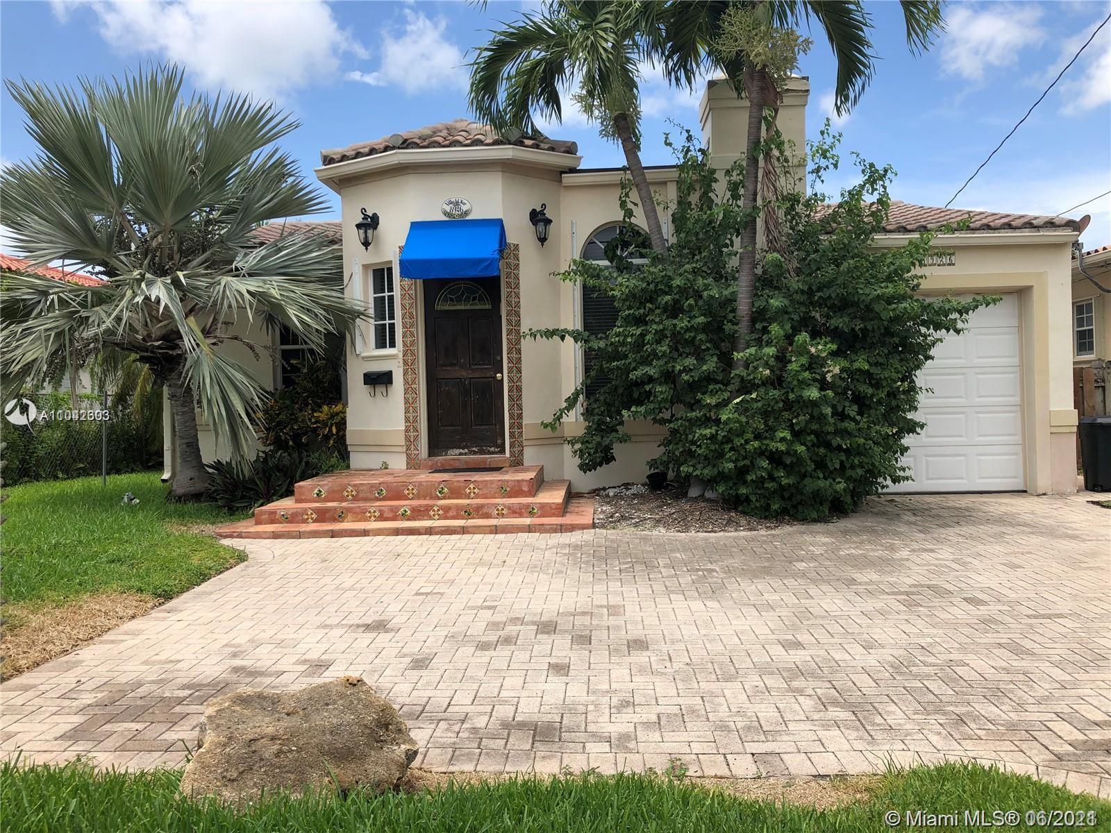 8926 Emerson Avenue Surfside, FL 33154 - Photo 1 of 18 a view of a white house with a small yard plants and palm trees