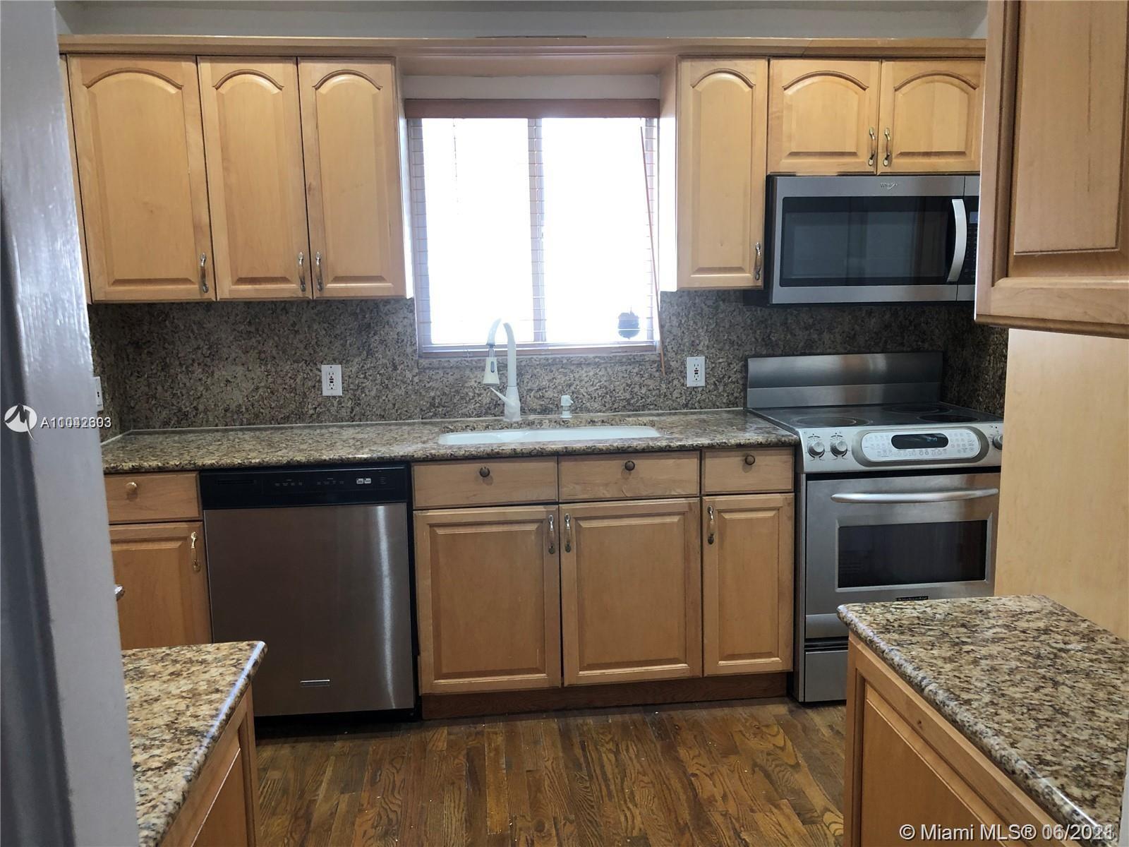 8926 Emerson Avenue Surfside, FL 33154 - Photo 11 of 18 a kitchen with stainless steel appliances granite countertop a stove a sink and a microwave