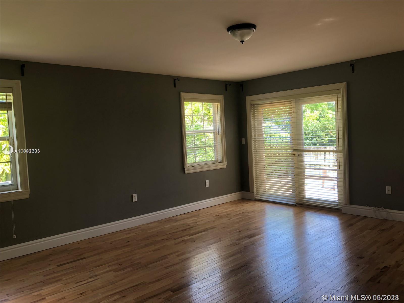 8926 Emerson Avenue Surfside, FL 33154 - Photo 12 of 18 a view of an empty room with wooden floor and a window