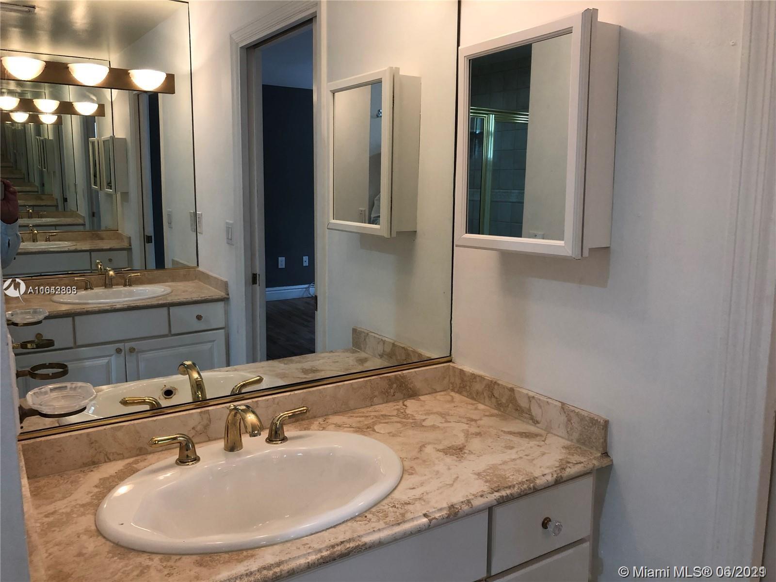 8926 Emerson Avenue Surfside, FL 33154 - Photo 14 of 18 a bathroom with a sink and a mirror