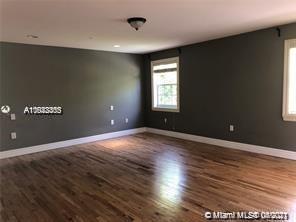 8926 Emerson Avenue Surfside, FL 33154 - Photo 15 of 18 an empty room with wooden floor and windows