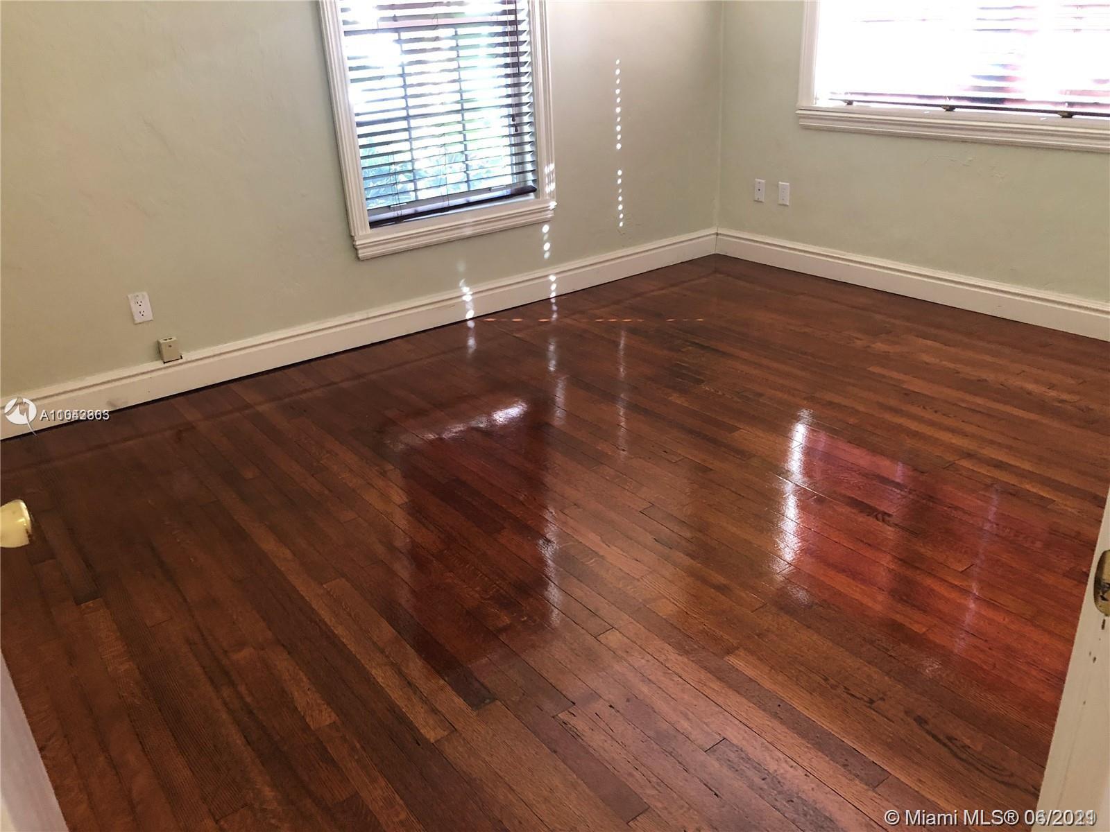 8926 Emerson Avenue Surfside, FL 33154 - Photo 16 of 18 an empty room with wooden floor and windows
