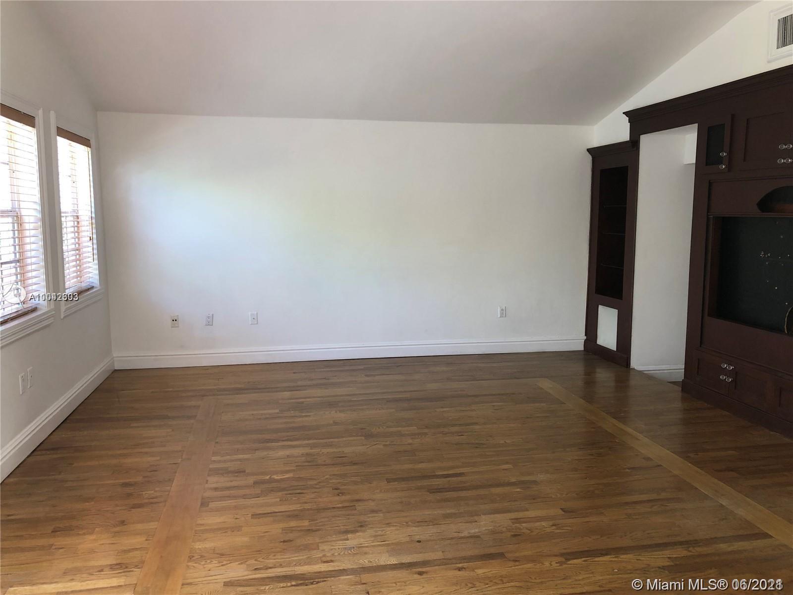 8926 Emerson Avenue Surfside, FL 33154 - Photo 4 of 18 a view of an empty room with window and wooden floor