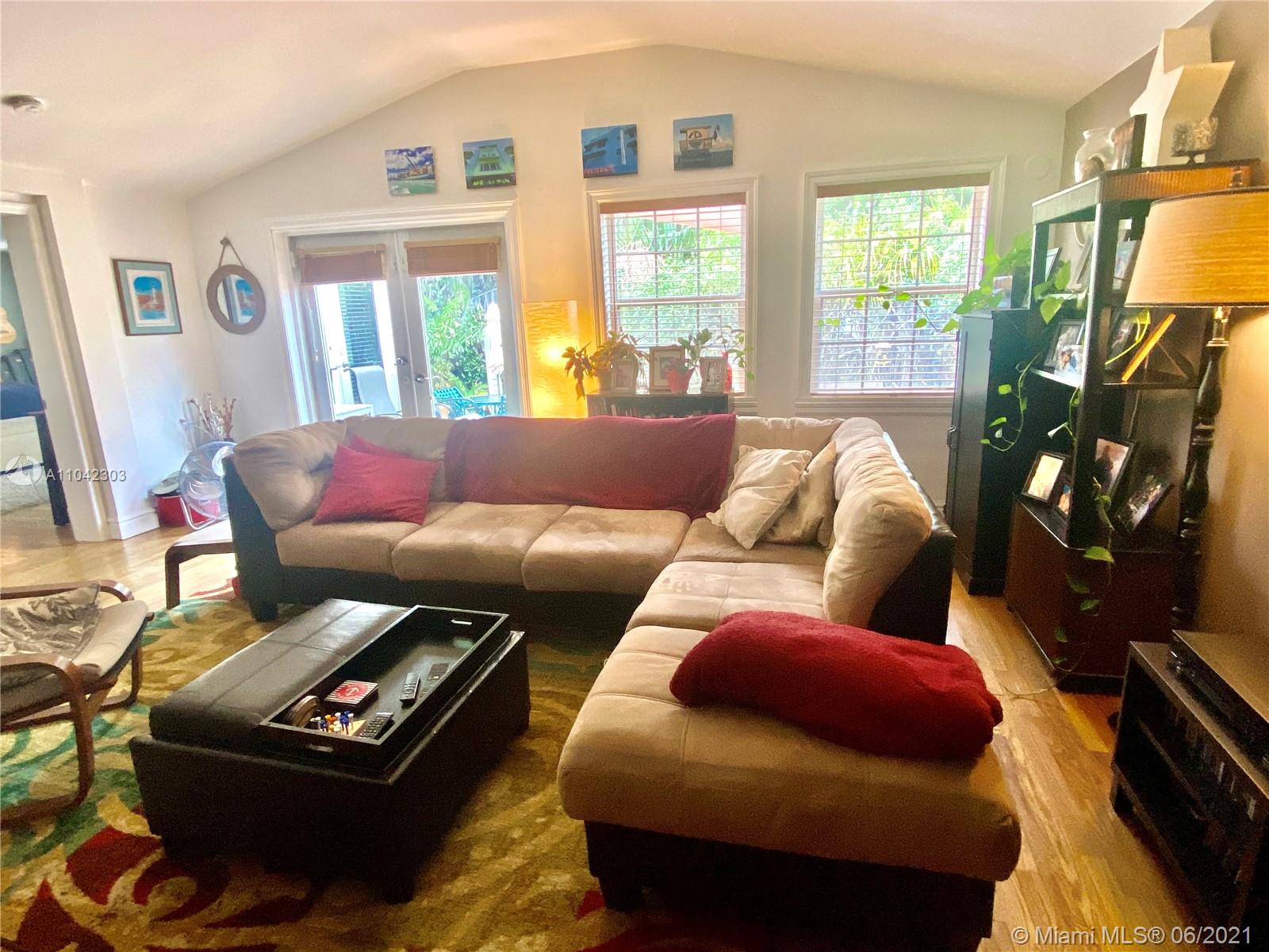 8926 Emerson Avenue Surfside, FL 33154 - Photo 5 of 18 a living room with furniture a flat screen tv and a large window