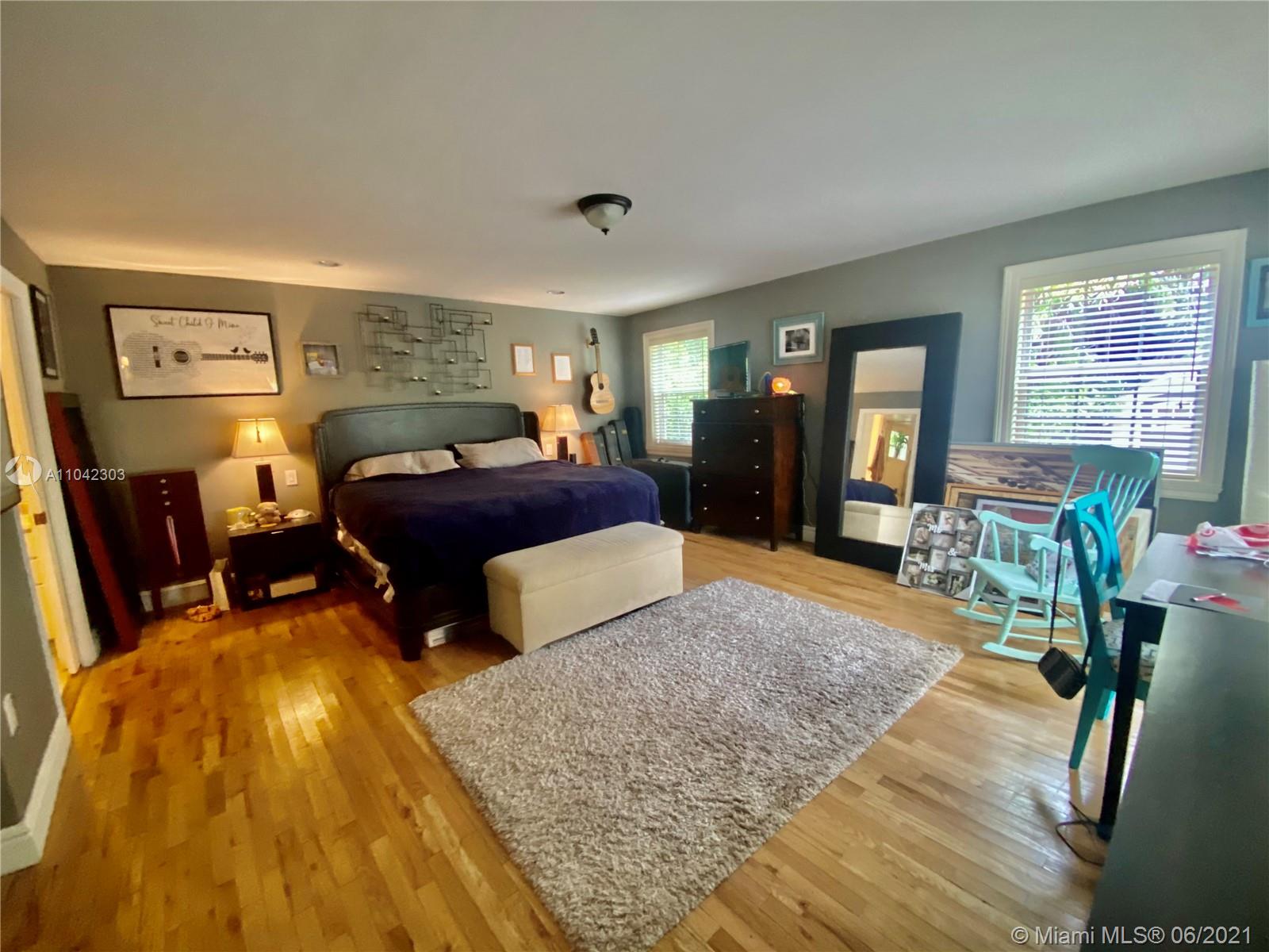 8926 Emerson Avenue Surfside, FL 33154 - Photo 7 of 18 a bedroom with a bed and wooden floor