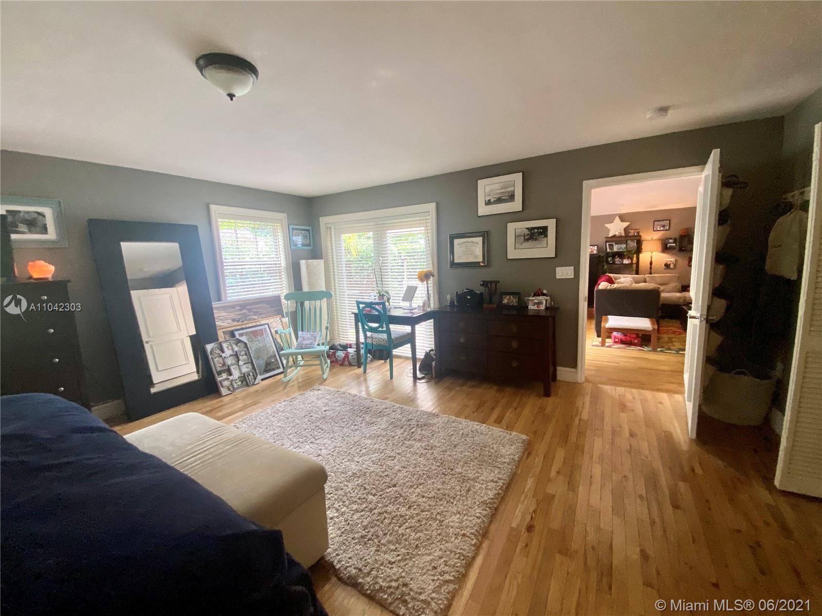 8926 Emerson Avenue Surfside, FL 33154 - Photo 8 of 18 a bedroom with a bed and wooden floor