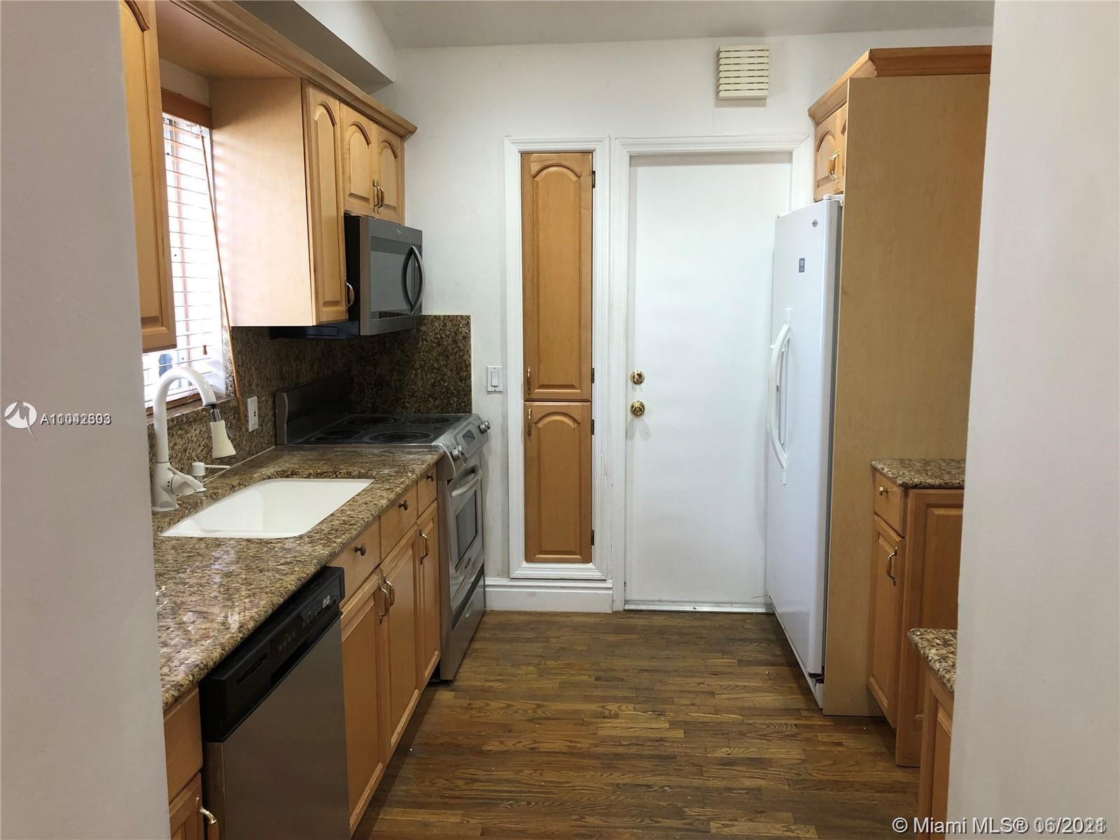 8926 Emerson Avenue Surfside, FL 33154 - Photo 10 of 18 a bathroom with a granite countertop sink and a mirror
