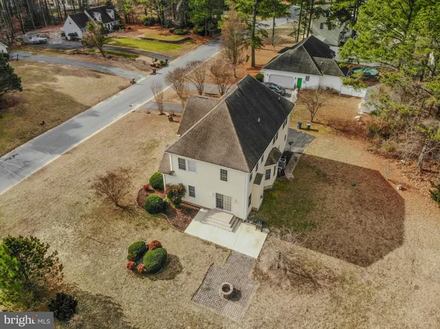 an aerial view of a house with swimming pool and large trees