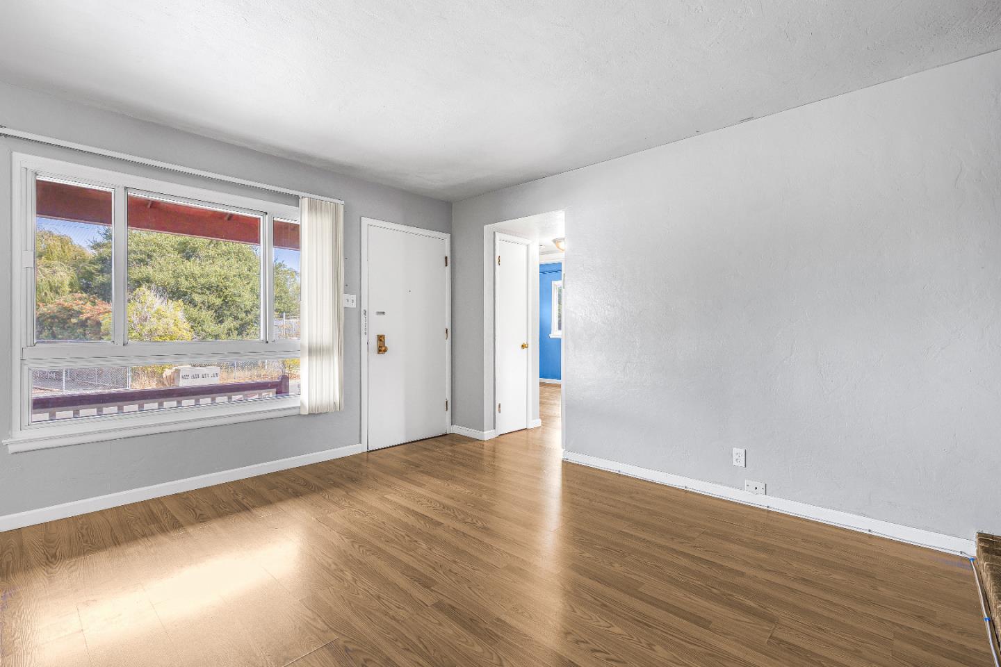 353 Cedar Street Millbrae, CA 94030 - Photo 7 of 19 a view of an empty room with wooden floor and a window