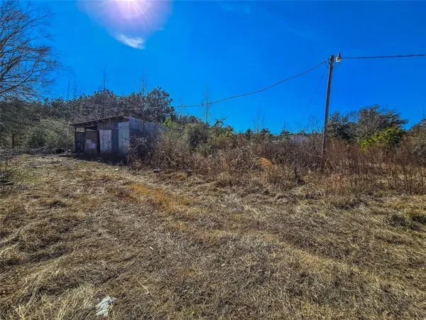 a view of a field with a house in background