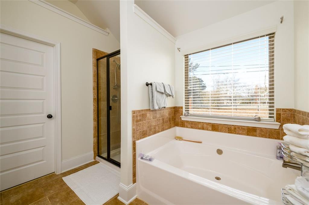 1979 Trinity Mill Drive Dacula, GA 30019 - Photo 24 of 38 a bathroom with a bathtub and a shower