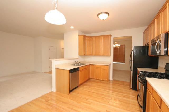 216 Longview Drive Elgin, IL 60124 - Photo 6 of 20 a kitchen with stainless steel appliances granite countertop a stove a sink and a refrigerator
