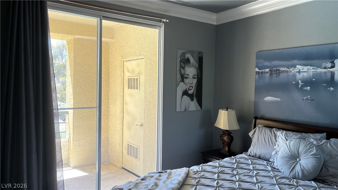 210 East Flamingo Road, Unit 205 Las Vegas, NV 89169 - Photo 11 of 17 Sliding glass doors offer access to an outdoor area, enhancing this cozy primary bedroom.