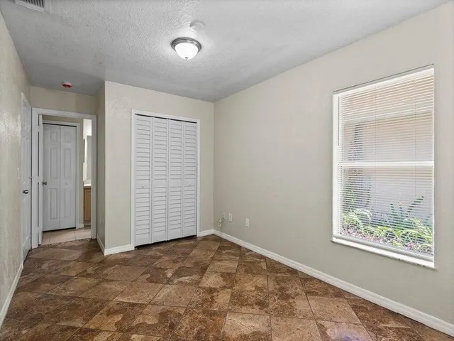 an empty room with windows and closet