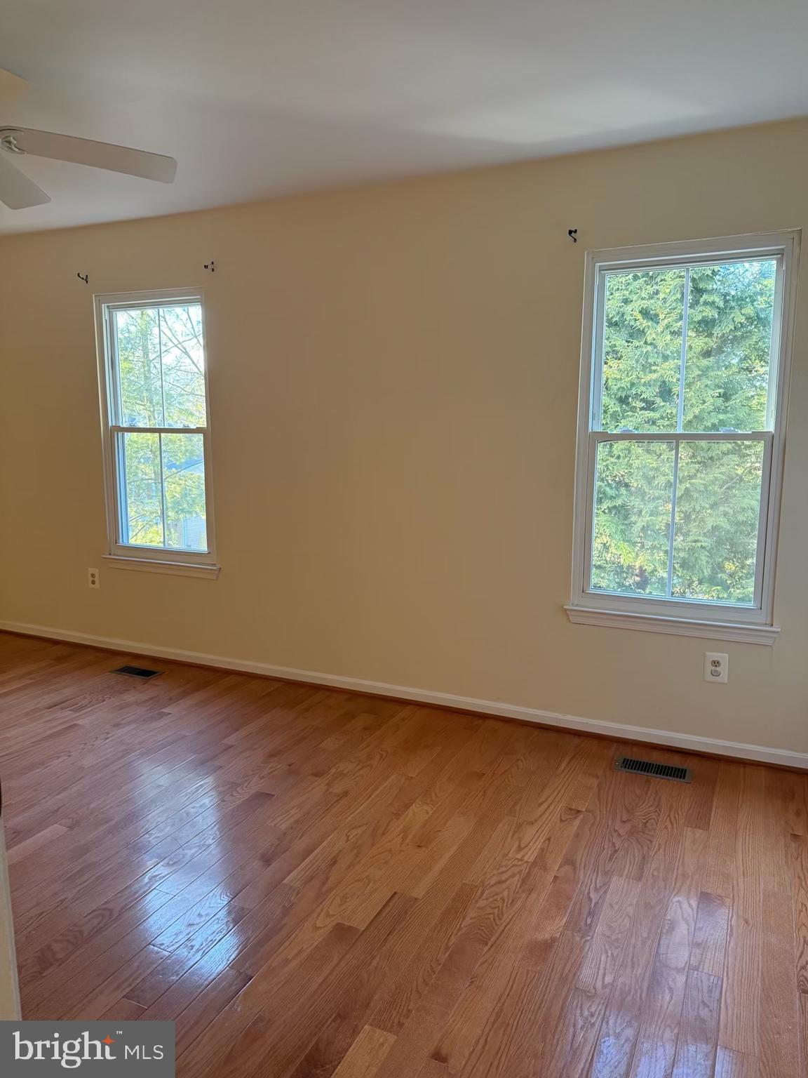 18272 Rolling Meadow Way Olney, MD 20832 - Photo 17 of 21 an empty room with wooden floor and windows