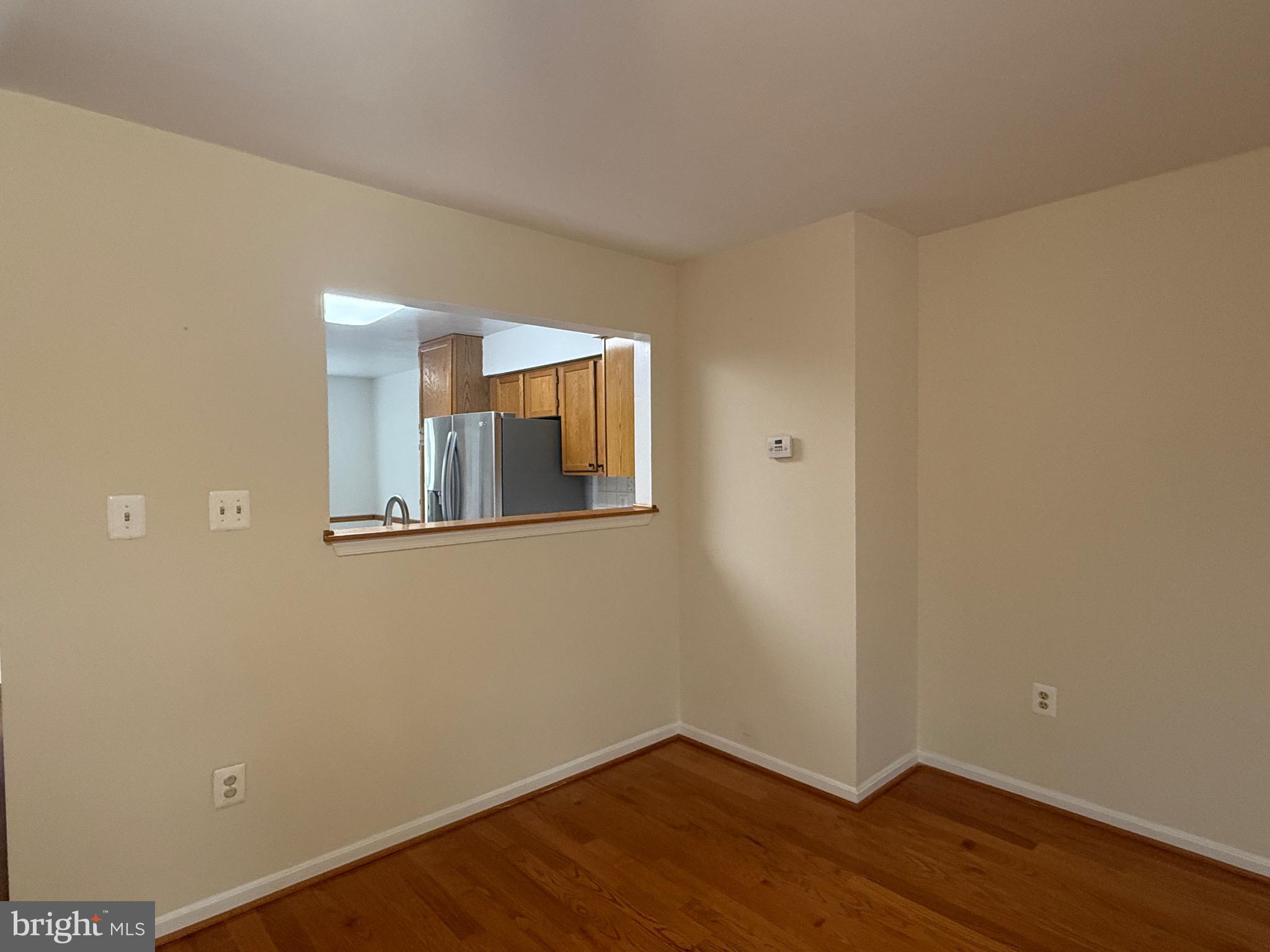 18272 Rolling Meadow Way Olney, MD 20832 - Photo 7 of 21 a view of an empty room with wooden floor and a window