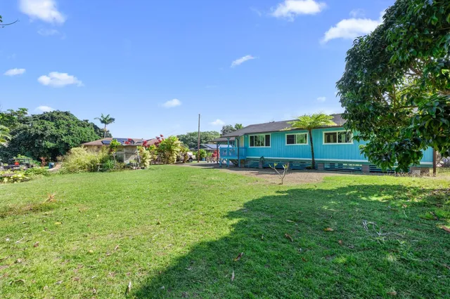a view of a house with a big yard and potted plants