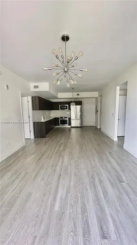 a view of a room with wooden floor and a ceiling fan