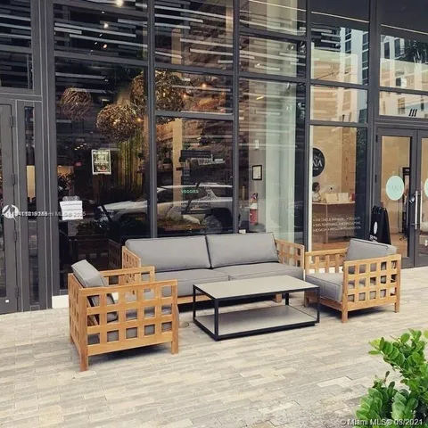 a building outdoor space with patio furniture and potted plants