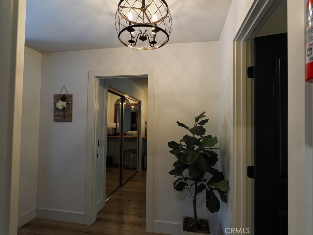 28596 North Bay Road Lake Arrowhead, CA 92352 - Photo 62 of 69 a view of a hallway with wooden floor and a chandelier