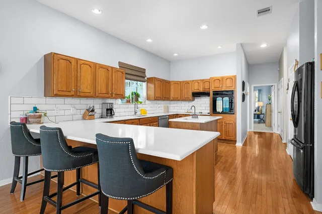a kitchen with stainless steel appliances kitchen island granite countertop a sink and cabinets