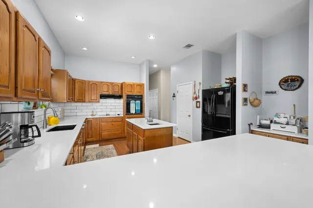 a kitchen with stainless steel appliances kitchen island a refrigerator sink and stove