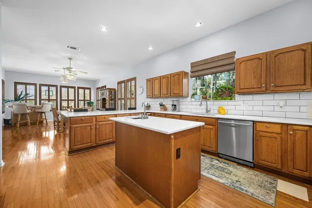 a kitchen with stainless steel appliances granite countertop a stove a sink dishwasher and a refrigerator