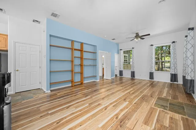 a view of empty room with wooden floor and windows