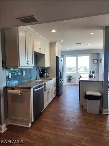 a kitchen with a sink cabinets and wooden floor