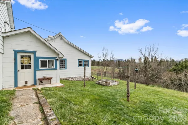 a view of a house with backyard and a tree