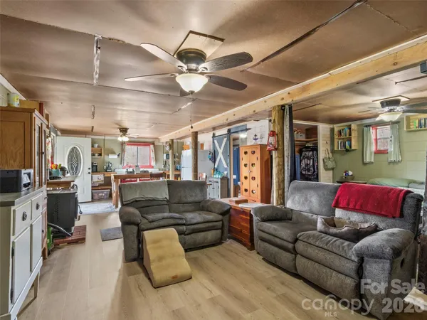 a living room with furniture kitchen view and a flat screen tv